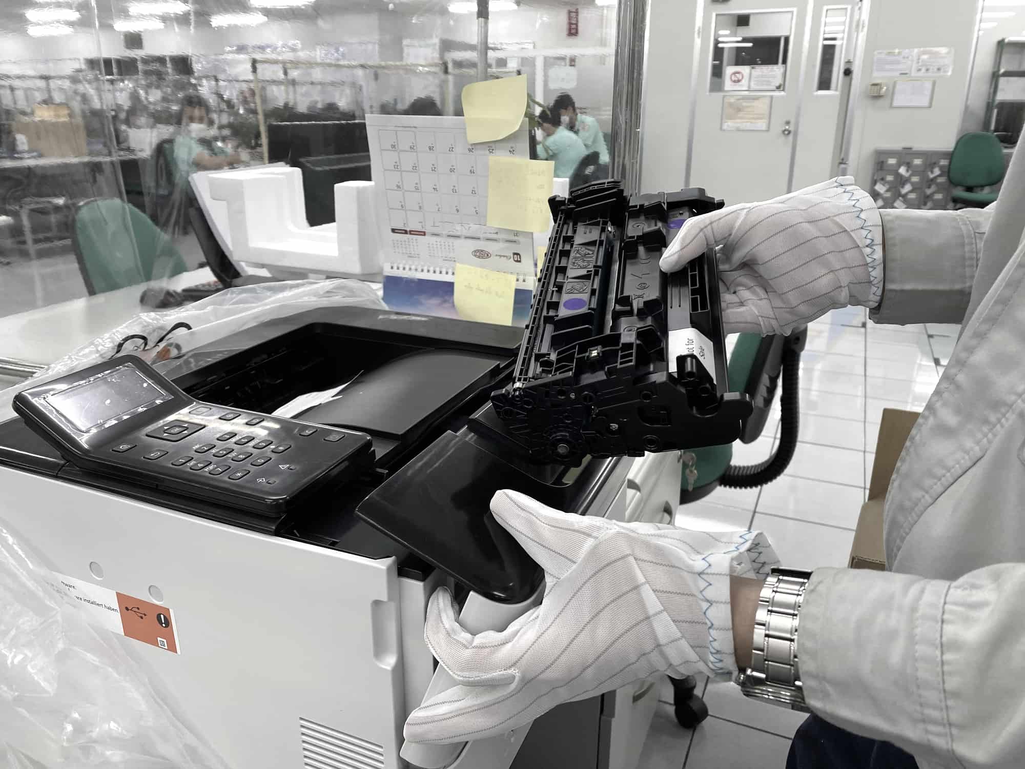 A person replacing a toner cartridge in a laser printer
