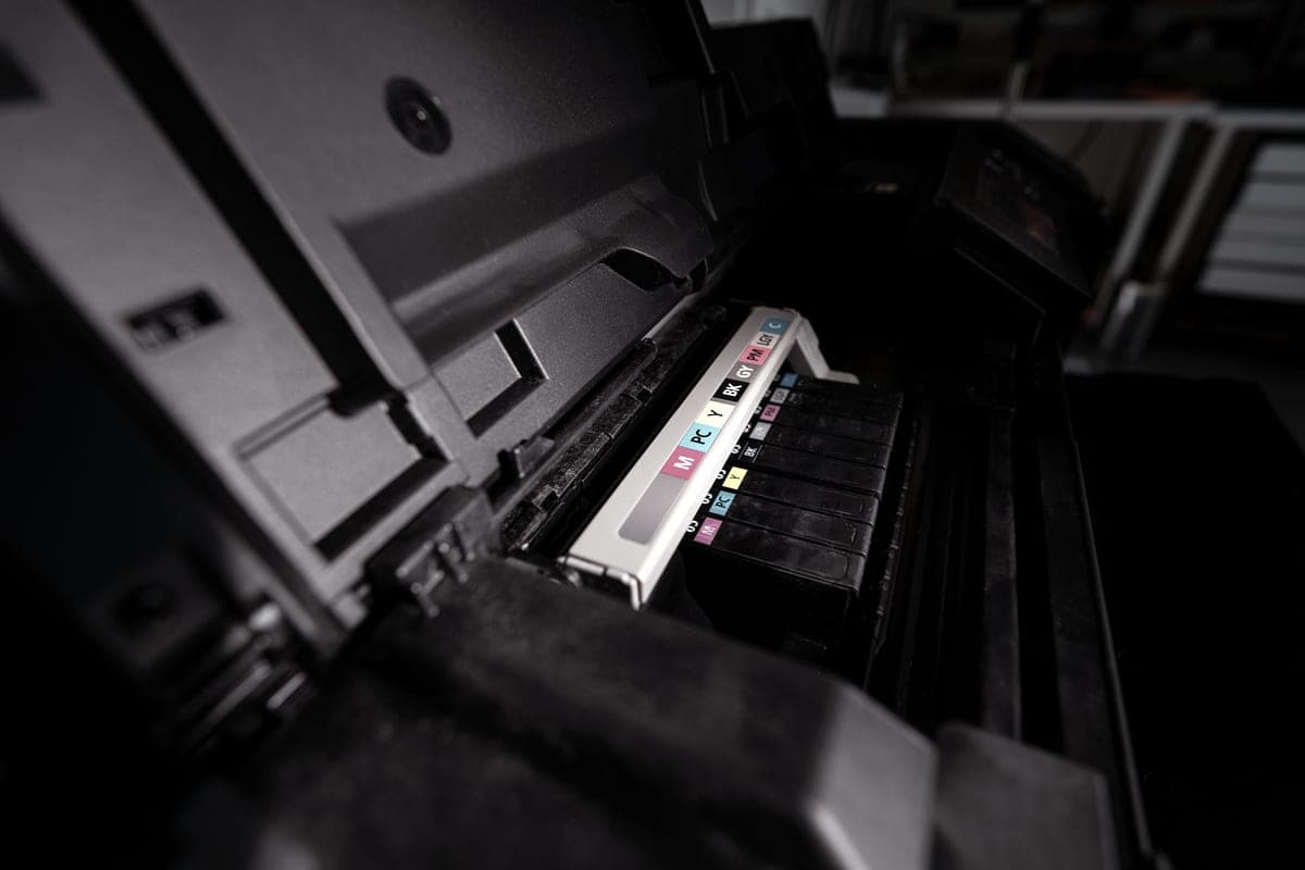 An open inkjet printer with its color ink reservoirs visible
