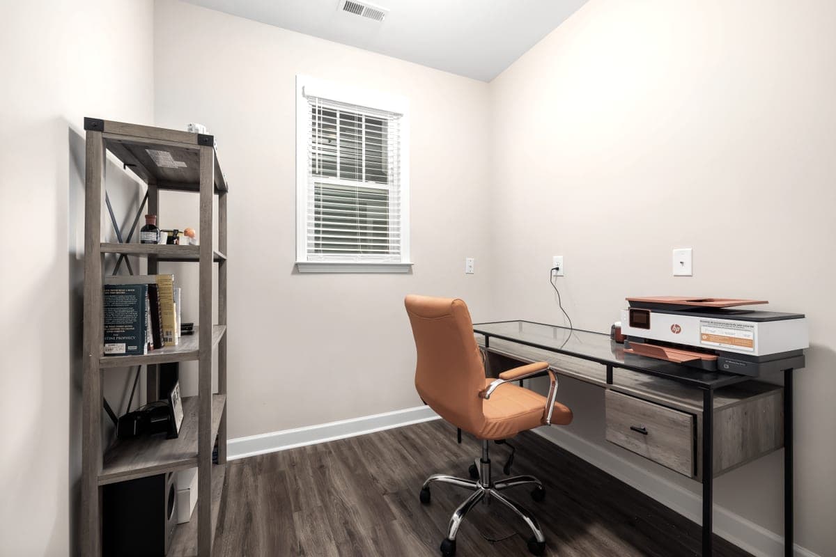 A tidy, uncluttered home office with a glass desk and a single chair
